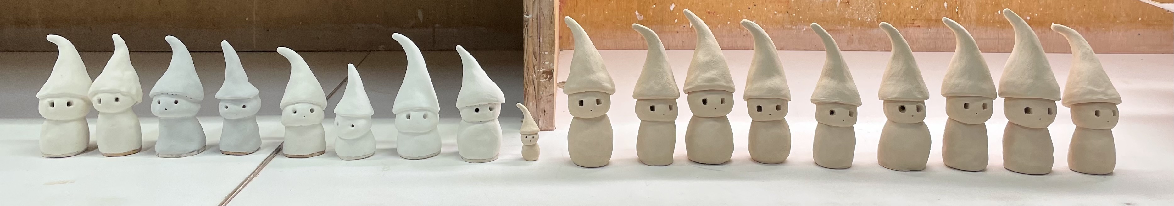 dozens of ceramic gnomes, unglazed