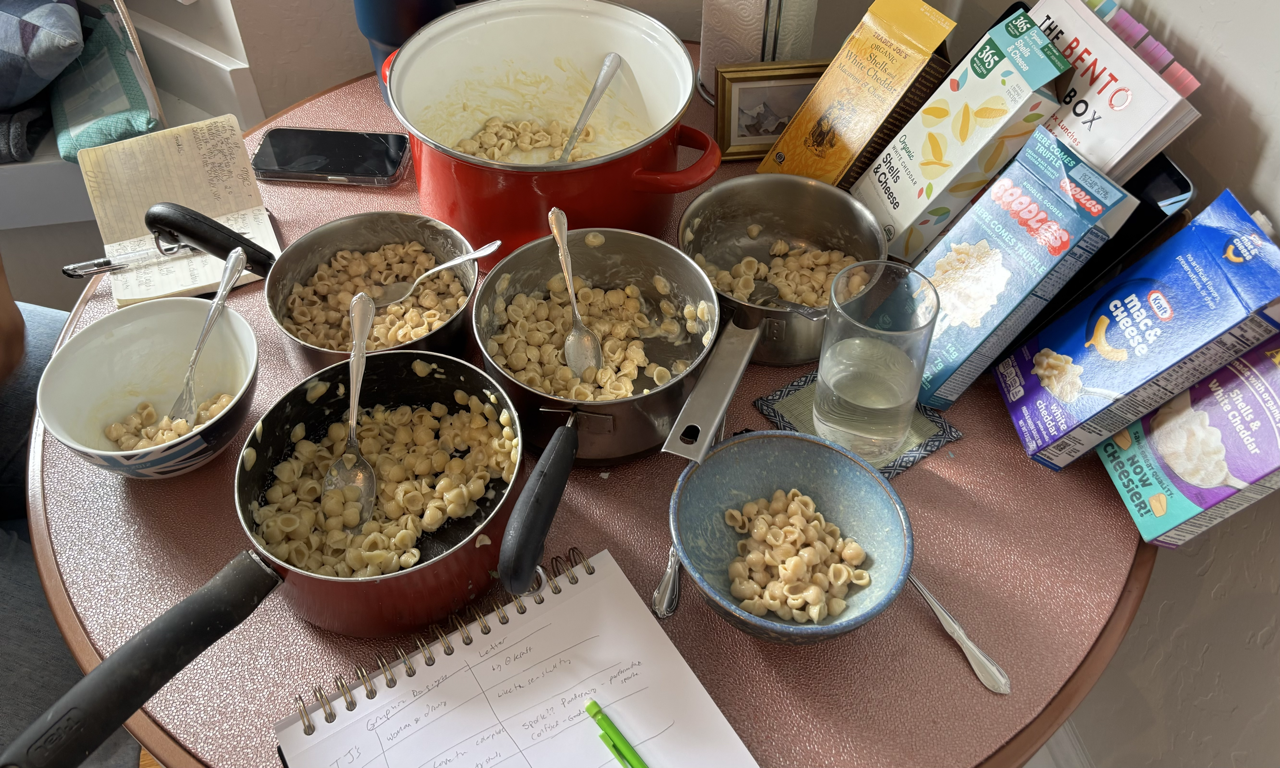 five pots of mac and cheese. one table.